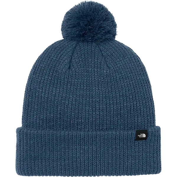 Blue knit beanie with pom-pom on a white background