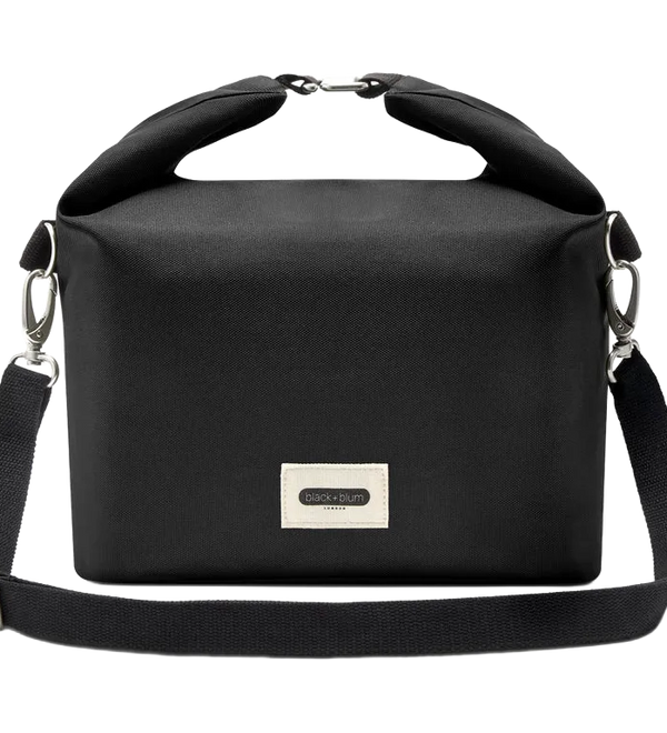 A black roll-top crossbody bag with a top handle, adjustable shoulder strap, and a silver-tone metal brand plaque on the front, shown against a plain white background