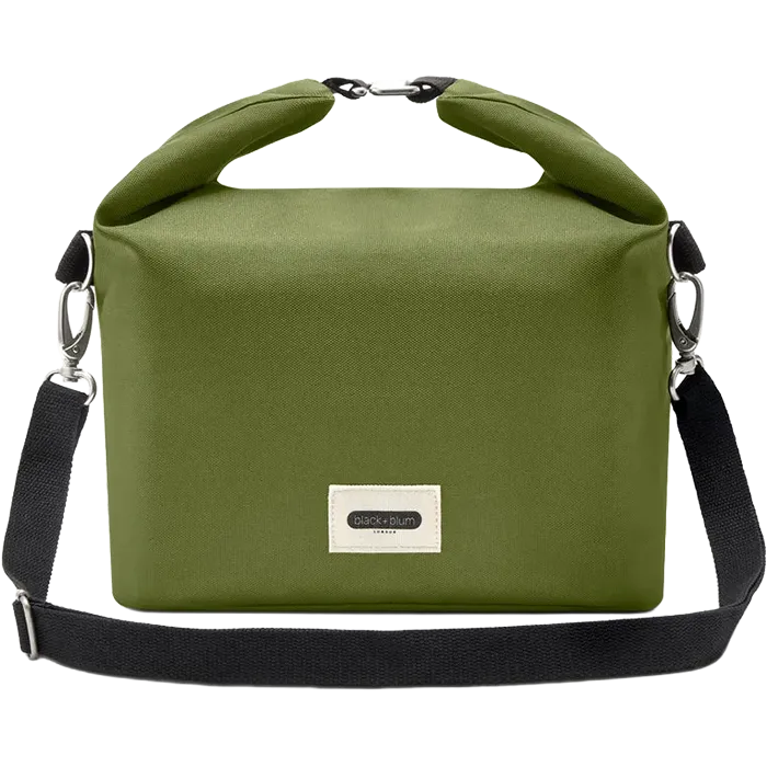An olive green roll-top bag with a black shoulder strap and silver metal hardware, featuring a small white brand label on the front.