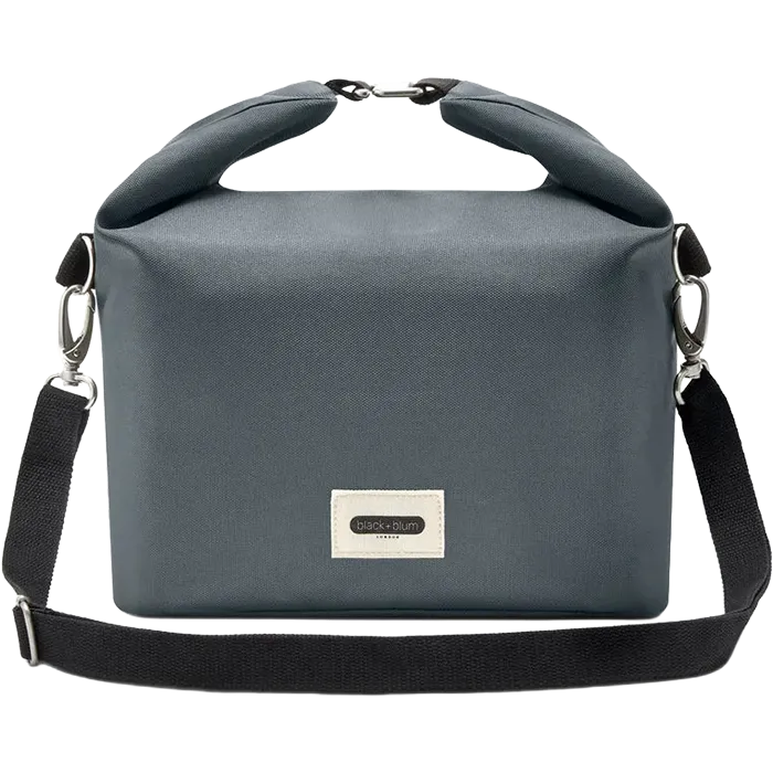 A dark gray roll-top crossbody bag with a black shoulder strap and silver hardware, featuring a white brand label on the front.