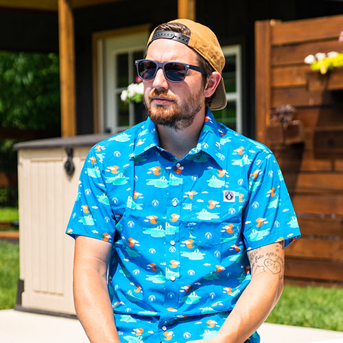 Man wearing a blue patterned shirt sitting outdoors