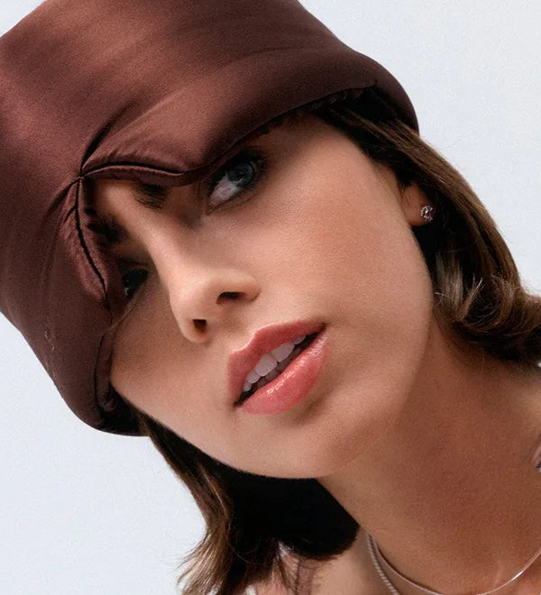 Woman wearing a brown Drowsy satin headscarf on a white background