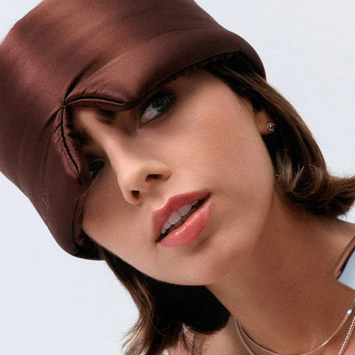 Woman wearing a brown Drowsy satin headscarf on a white background