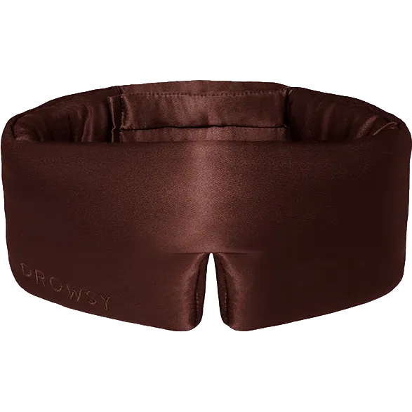 A Drowsy brown satin sleep mask with a padded brow support band, featuring the brand name 'DROWSY' debossed on the lower left corner, set against a plain white background.