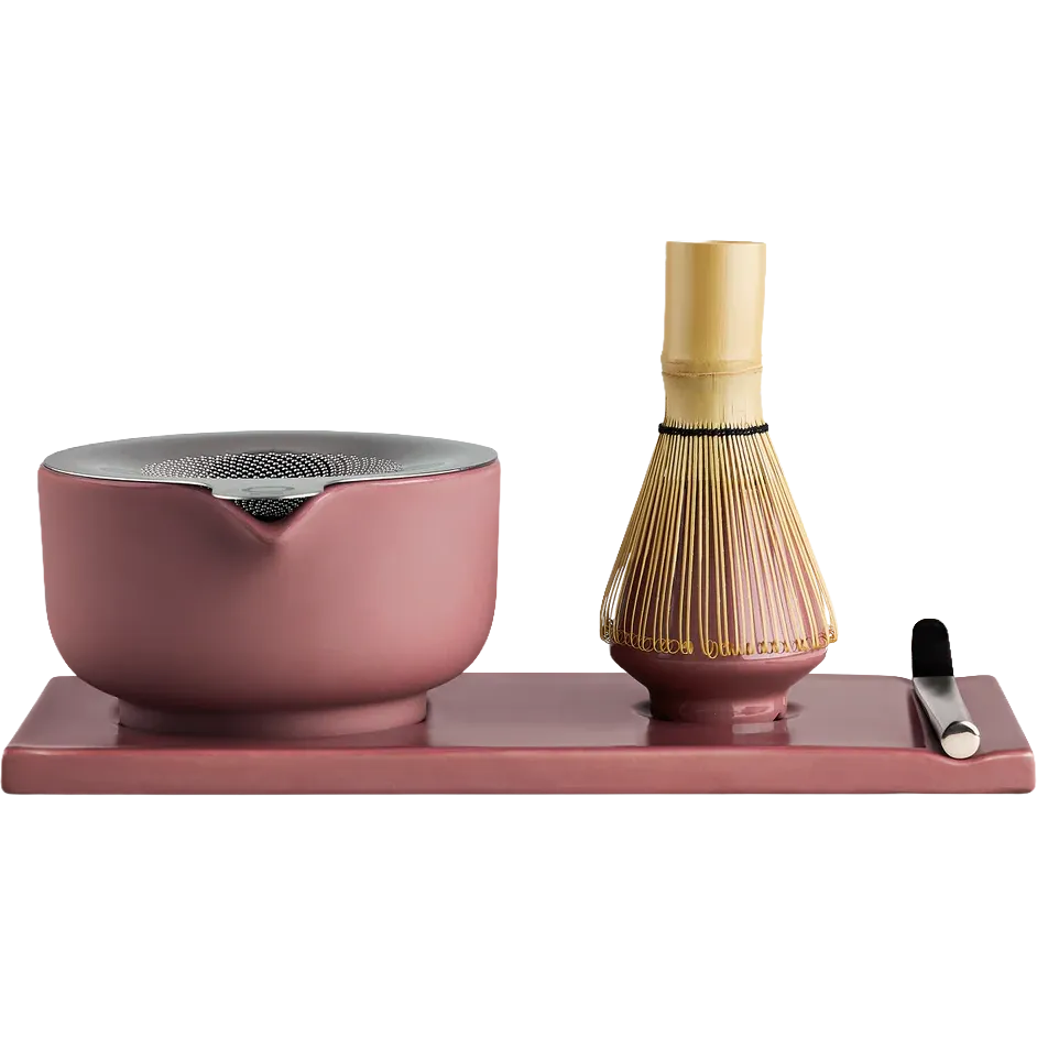 Fellow matcha tea set on a rectangular tray, featuring a dusty pink ceramic bowl with a metal lid, a bamboo whisk, and a small metal scoop on a solid white background.