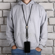 Person wearing a gray hoodie with a black lanyard and phone holder against a brick wall.