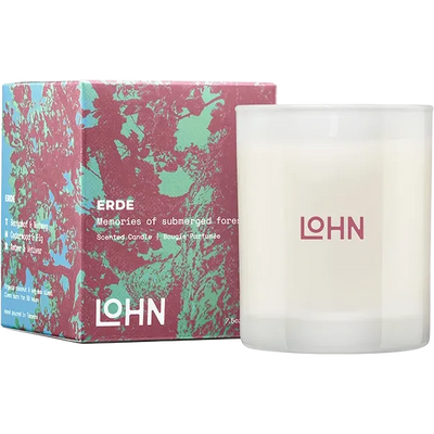A frosted glass scented candle next to its colorful box. The candle is white with the brand name 'LOHN' printed in pink on the front.