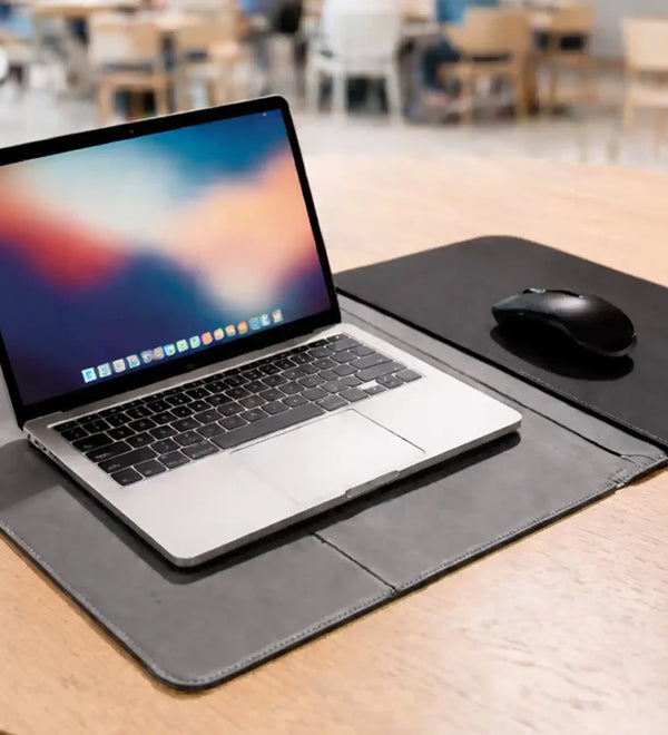 Laptop on a desk with a mouse and mouse pad 