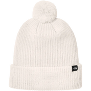 White knit beanie with pom-pom on a white background