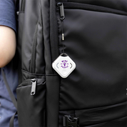 Black backpack with a white tag featuring purple text and graphics.